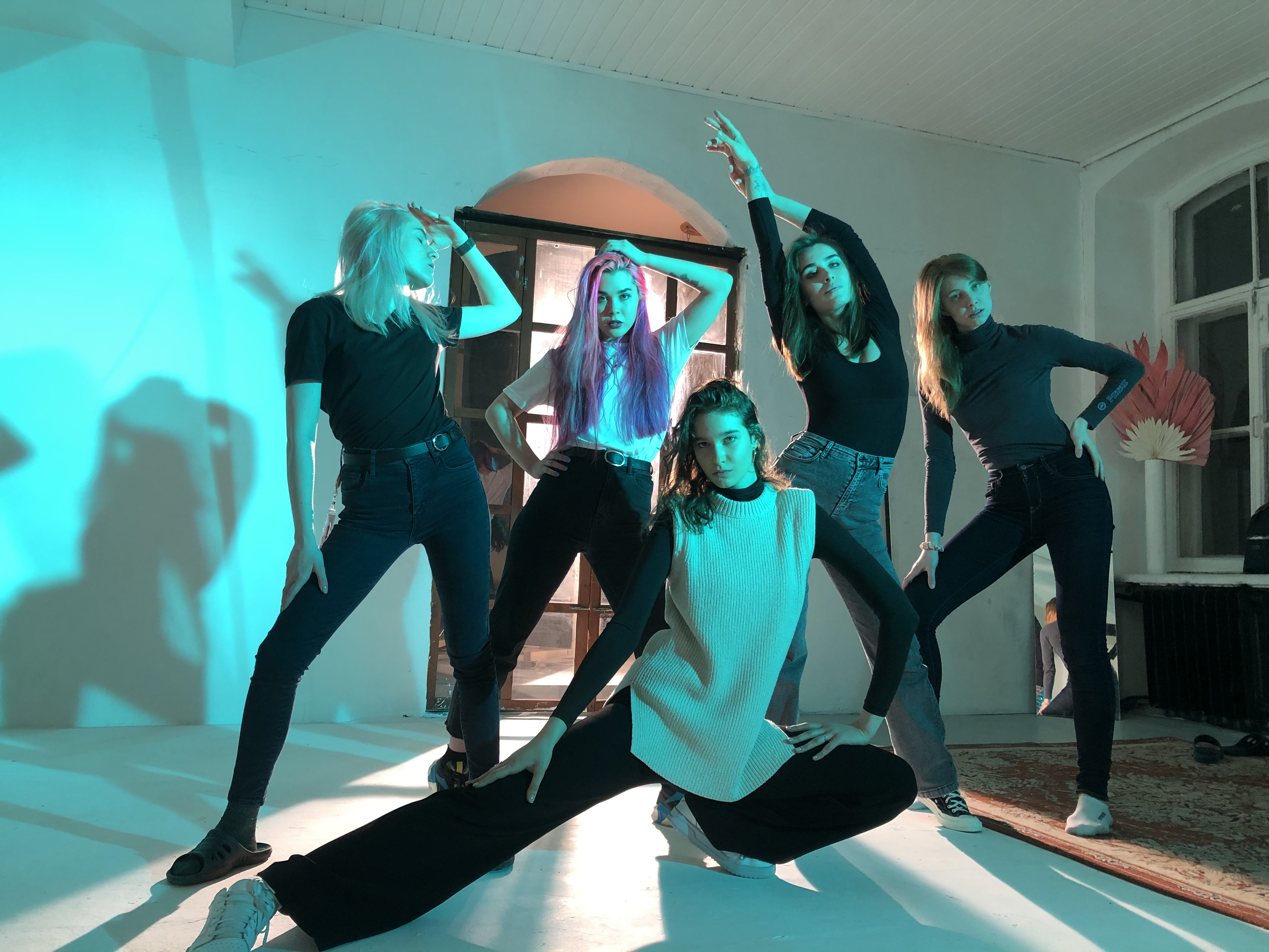 A workshop group posing together in a teal-lit studio